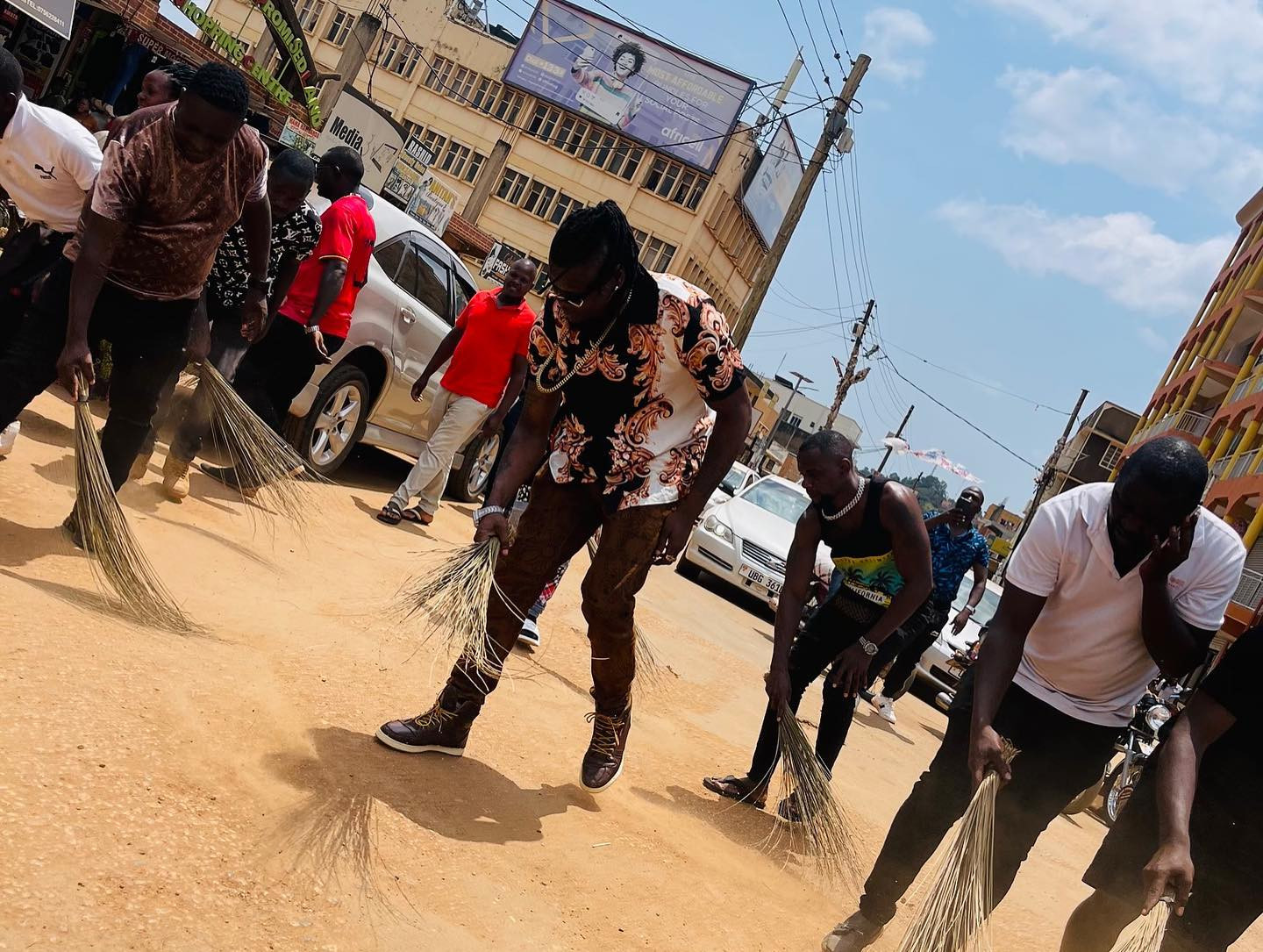 Popular Ugandan singer forced to sweep streets after turning up late for music show (photos/video) 